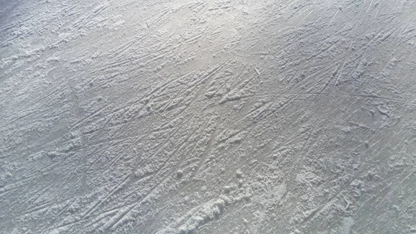 Ice streaked with the tip of figure skates. Figure skating on ice. The surface of the ice rink after the skaters exercise. Sunbeam on wet spring ice. Snow and frozen water — 스톡 사진