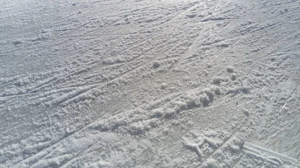 Gelo estriado com a ponta de patins artísticos. Patinação artística no gelo. A superfície da pista de gelo após o exercício de patinadores. Feixe de sol no gelo molhado da mola. Neve e água congelada — Fotografia de Stock