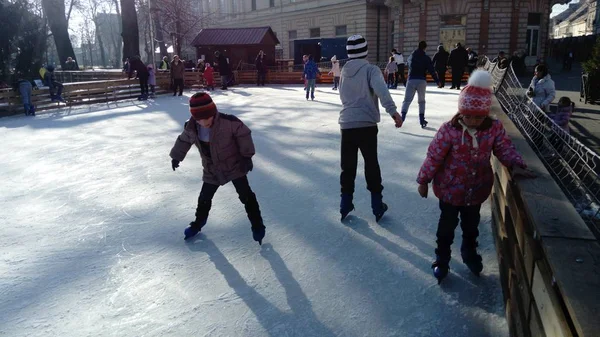 Belgrad, Sırbistan - 10 Ocak 2020 Çocuk ve yetişkinler şehir parkında buz pateni pistine çıktılar. Aktif sporcular eğlenir. Buz pistindeki buz, buz pateninin ucundaki izlerle çizilmiş.