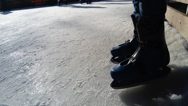 Korcsolyás láb. Sport egyenruhák és felszerelések. Jégpálya. Hosszú árnyékok a jégen az alacsony téli napsütéstől. — Stock Fotó