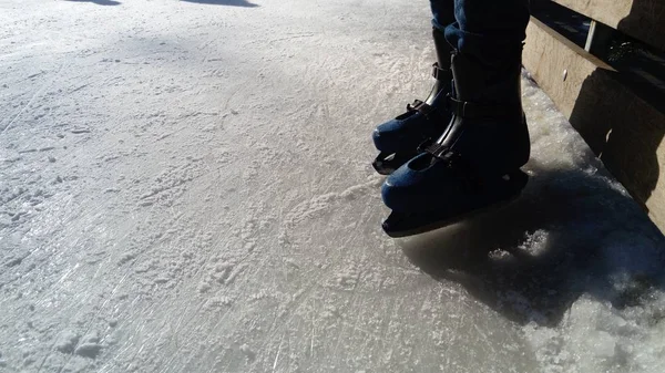 Pés com patins. Uniformes e equipamentos esportivos. Pista de gelo. Sombras longas no gelo do sol de inverno baixo . — Fotografia de Stock