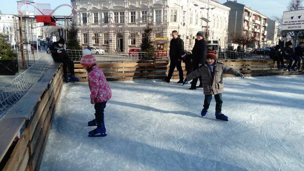 Belgrade, Serbia - January 10, 2020 Children and adults ride in the city park on an ice rink. Active sports people have fun. Ice on the rink is streaked with traces from the tip of figure skates — 스톡 사진