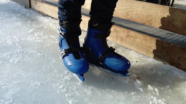 Pés com patins. Uniformes e equipamentos esportivos. Pista de gelo. Sombras longas no gelo do sol de inverno baixo . — Fotografia de Stock