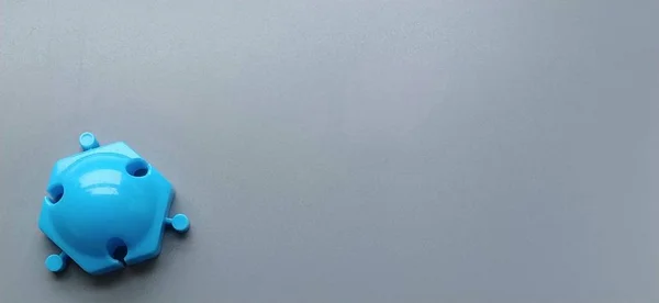 Blauwe schimmel van de kinderontwerpster op een grijze achtergrond. Glanzend plastic mozaïek detail. Kinderspeelgoed voor de ontwikkeling van verbeelding en fijne motoriek van handen — Stockfoto