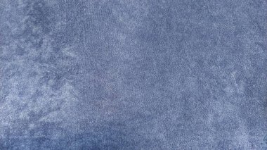 Blue velvet fabric. Dense, pleasant to the touch curtains close-up. Variant of interior decoration. Overflowing shades of blue on a short pile of material. Sewing product