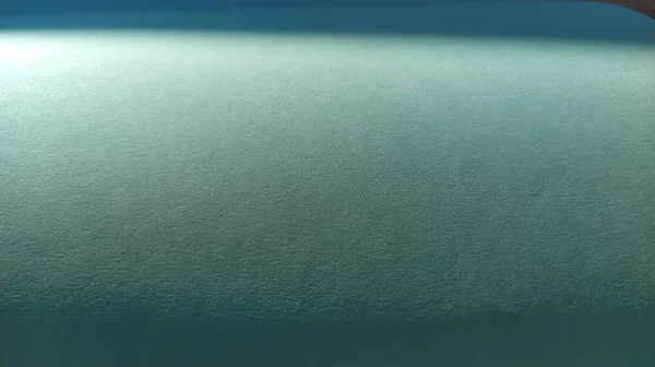 Ένα φύλλο ανοιχτού πράσινου χαρτιού με βινιέτα στο κάτω μέρος. Γαλήνιο πράσινο με λεπτή υφή χαρτιού. Καταπραϋντικό εσωτερικό χρώμα. Ελαφρώς διπλωμένο φύλλο — Φωτογραφία Αρχείου