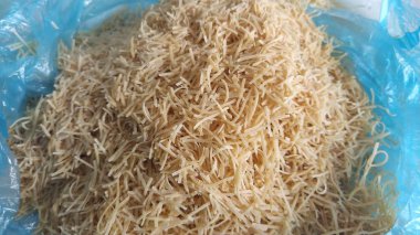 İnce, kuru vermicelli. Glüten, vitamin, karbonhidrat, protein ve yağ içeren buğday unu ürünü. Mavi plastik torbada küçük bir makarna. Fast food