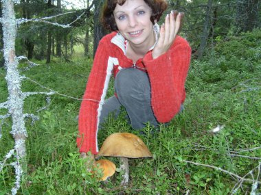 Kız büyük güzel bir mantar buldu. Kadınlar, otların ve yosunların içinde mantar bulmaktan mutluluk duyarlar. Bir adam fermuarlı kırmızı bir kazak giyiyor. Eller havaya, yüzler güler yüzlü ve şaşırmış.