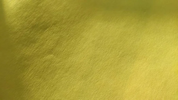 这种纸或织物是亮黄色的.特写。薄薄的折页。光梯度和突出的粗糙表面纹理.背景或产品样本.阳光灿烂的黄色 — 图库照片