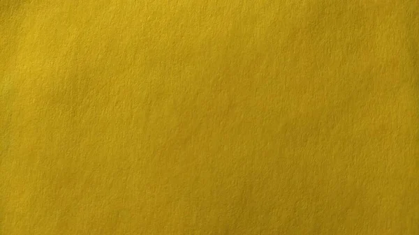 O material de papel ou tecido é amarelo brilhante. Close-up. Folha ligeiramente dobrada. Gradiente de luz e acentuada textura superficial áspera. Amostra de fundo ou produto. Amarelo alegre ensolarado — Fotografia de Stock