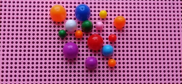 Board game - a mosaic for the development of mental and creative abilities of the child. Pink plastic box with holes. On the left, multi-colored chips and forms to create a plot