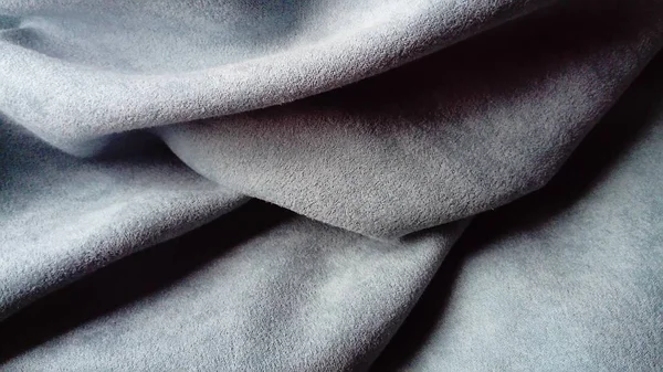 Gros plan de tissu épais velouté pour rideaux de couleur gris-bleu plissé avec le jeu de chiaroscuro — Photo