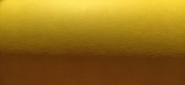 O material de papel ou tecido é amarelo brilhante. Close-up. Folha ligeiramente dobrada. Gradiente de luz e acentuada textura superficial áspera. Amostra de fundo ou produto. Amarelo alegre ensolarado — Fotografia de Stock
