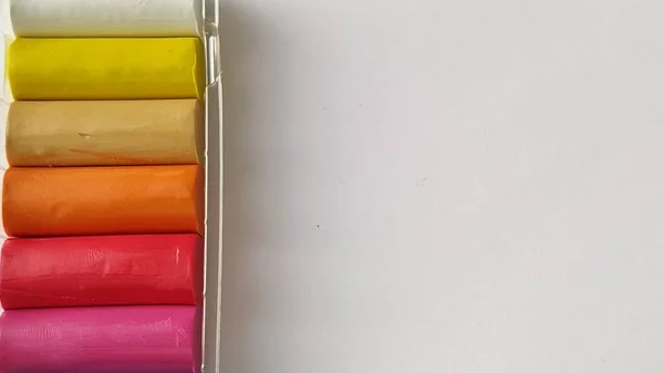 Nueva plastilina multicolor en envases de plástico sobre fondo blanco. Placas de plastilina de rojo, rosa, verde, blanco, amarillo, marrón, azul, negro. Set para la creatividad infantil —  Fotos de Stock