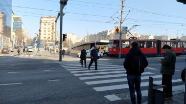 Belgrade, Serbia - January 24, 2020: pedestrian crossing with people on Slavia Square in the center of Belgrade. Active traffic, pedestrians cross the road on the white zebra stripes. Road marking