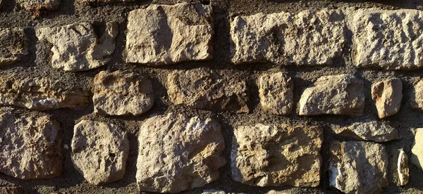 Antique brickwork. Wall in the cultural and historical complex of the Belgrade Fortress, Serbia. Sunny evening lighting. Warm brown, red, orange beige tones. Destruction and change on the stone
