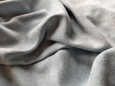 Kumaş perdenin kumaşı. Güzel gri-mavi renk. Yığınla yumuşak kadife. Perde malzemesi dikkatsizce katlanır ve yatay bir yüzeyde kırışır. Kumaş örneği. İç tasarım seçeneği.
