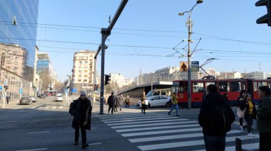 Belgrade, Serbia - January 24, 2020: pedestrian crossing with people on Slavia Square in the center of Belgrade. Active traffic, pedestrians cross the road on the white zebra stripes. Road marking