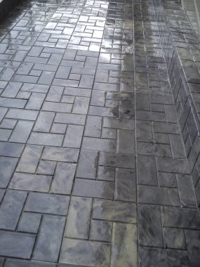 binadan gölge ile yağmur dan sonra kaldırımda ıslak gri kiremit.