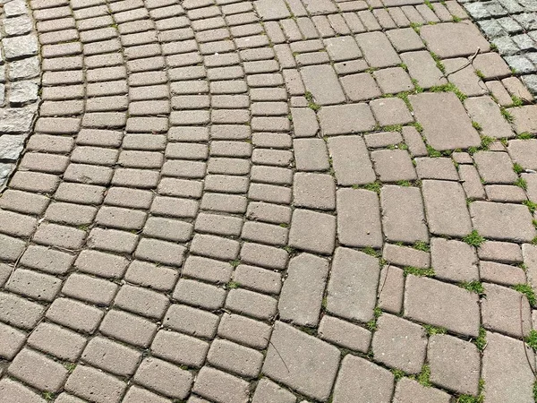 旧市街の石畳の通り 正方形と長方形の石のタイルが混沌とした方法で並んでいます 柔らかいベージュまたは黄色の色とトーン 石の質感 幾何学模様 — ストック写真