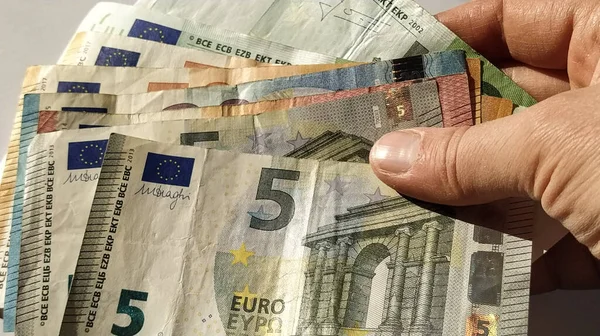 欧元纸币 欧洲货币在白色背景下的特写 老年人或中年妇女的手和手指靠金钱吃饭 中央银行5 50和100的钞票 — 图库照片