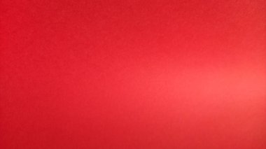 Güzel, kırmızı, parlak arka plan. Işığa göre renk eğimine bağlı. Kırmızının düz olmayan rengi. Doğal ışık ile renklendirilmiş bir kağıt parçası. Parlak bir ışık saçan renkli kağıt parçası..