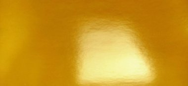 Güzel sarı bir arka plan. Yakın plan bir kağıt parçası. Saf neşeli bir renk. Parlak sarı tonu, turuncuya yakın ve parlak. Parlak bir yüzeyde ışığın yansıması.