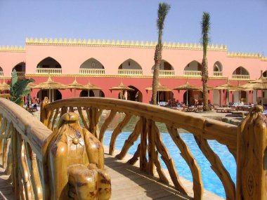 Hurghada, Mısır - 20 Mart 2020: Hurghada 'daki otellerin güzel genel manzarası, havuz, şemsiyeler, dinlenme yerleri. Afrika 'da plaj tatili sezonu. Su üzerinde tahta köprüler.