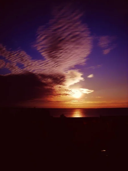 Soloppgang i nord. Kul morgen med daggry over Onega i Karelen. En gul sol stiger over horisonten. Himmelen er rød, lilla og rød. Stratokumulus-skyer. Solnedgang på sjøen med refleksjon – stockfoto