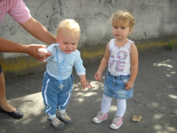 Sremska Mitrovica セルビア 2019年7月1日子供は大人と一緒に歩く 男の子と女の子が道路で会った 子供たちは知識を得てコミュニケーションします 赤ん坊は口の中に青い乳首がある — ストック写真