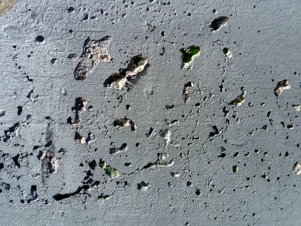 Parete di cemento con danni concentrici di ampio raggio. Buche, tubercoli e difetti. Colore grigio. Concetto di superficie del pianeta. Parete di cemento con una superficie usurata, buche, rigonfiamenti e piccole macchie . — Foto Stock