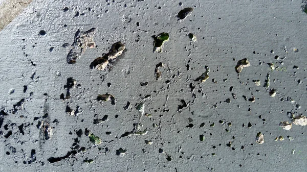 Concrete wall with concentric damage of large radius. Potholes, tubercles and defects. Grey colour. Planet surface concept. Concrete wall with a worn surface, potholes, bulges and small spots. — Stock Photo, Image