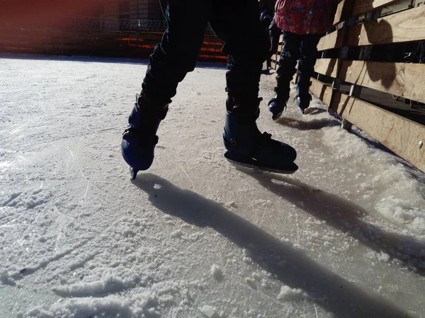 スケートと足 スポーツの制服や装備 アイスリンク低い冬の太陽からの氷の上の長い影 — ストック写真