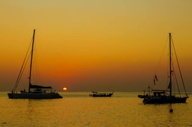 Denizde gün doğumu tekneyle