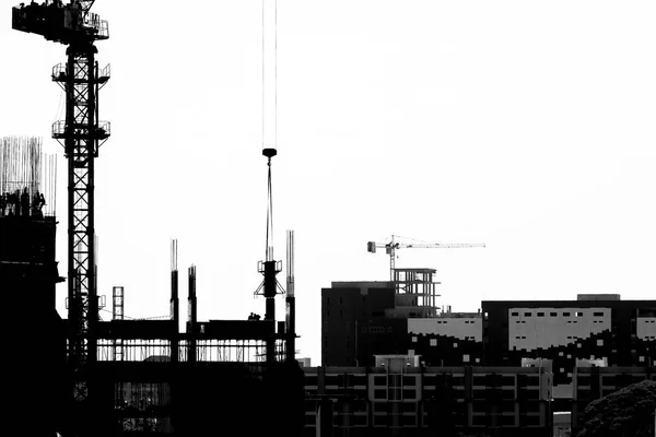 Site de construction avec grues sur fond de silhouette — Photo