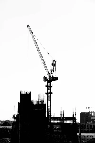 Site de construction avec grues sur fond de silhouette — Photo