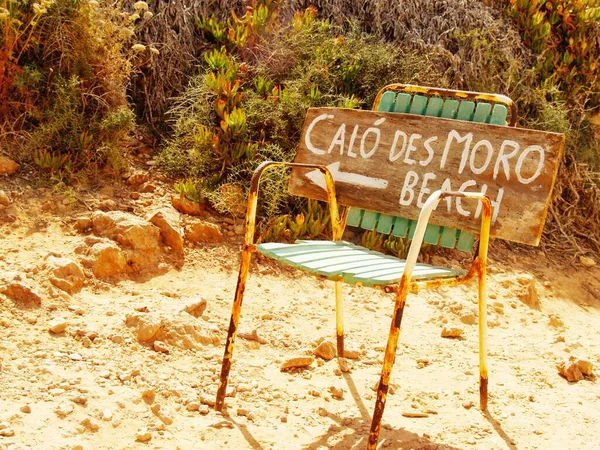 Calo des Moro plajındaki el yazısı paslı bir sandalyede Mallorca 'nın en popüler plajını gösteriyor.