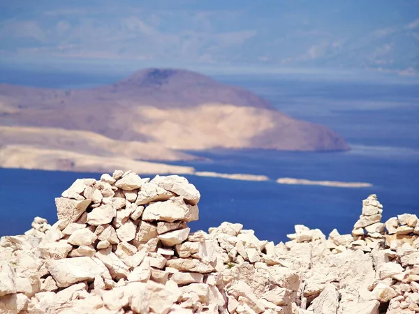 Taştan oluşmuş, arka planda adalar ve deniz manzaralı, Hırvatistan 'ın başkenti Rab' bin en yüksek tepesi Kamenjak 'ın kuru manzaralı kuru taş duvar manzarası.