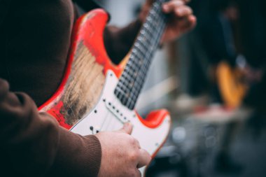 Konserde elektro gitar çalan bir adam.