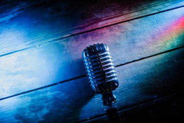 Retro microphone on wooden background and lights clipart