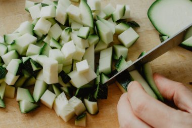 Tahta bir tahtanın üzerinde bıçakla kabak doğramak. Ev yapımı mutfak.