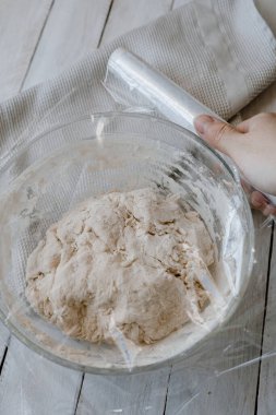 Plastikle kaplanmış ev yapımı ekmek hamuru olmayan bir kase.