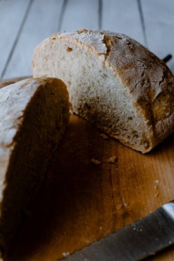Lezzetli ev yapımı yoğurtsuz ekmek. Tahta üzerinde ikiye bölünmüş.