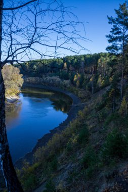 Orman ve vadiler arasında güzel bir nehir. Ağaçların ve çam ağaçlarının arasında. Nehir ovalardan, vadilerden, huş ağaçlarından, çam ağaçlarından ve tarlalardan kilometrelerce uzanıyor..