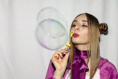 Saçları örgülü, sabun köpüğü sallayan tatlı bir kız.