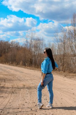 Kumlu bir yolda kelepçeli bir polis kız.