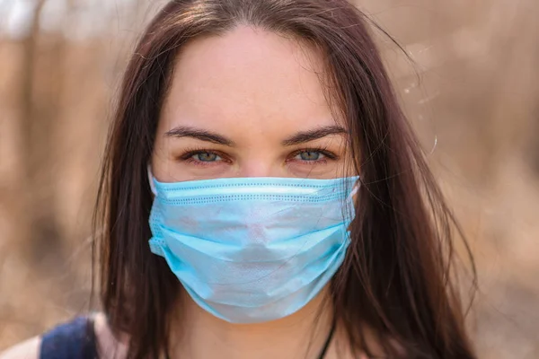 Salgına karşı savaşan genç bir kız tıbbi bir maske taktı.