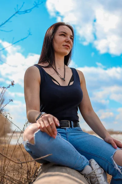 Ein Schönes Mädchen Sitzt Jeans Und Schwarzem Shirt Auf Einem — Stockfoto