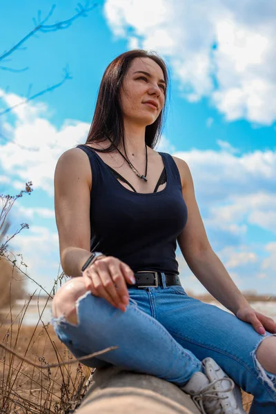 Uma Linda Garota Está Sentada Tronco Margem Rio Jeans Uma — Fotografia de Stock