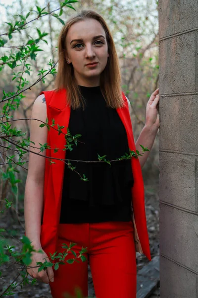 Uma Menina Roupas Vermelhas Encostada Contra Uma Parede Bloco Perto — Fotografia de Stock